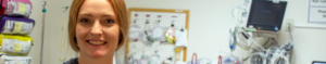 new nurse standing in emergency room, smiling
