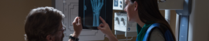 Physician assistant looking at workers compensation x-ray with patient